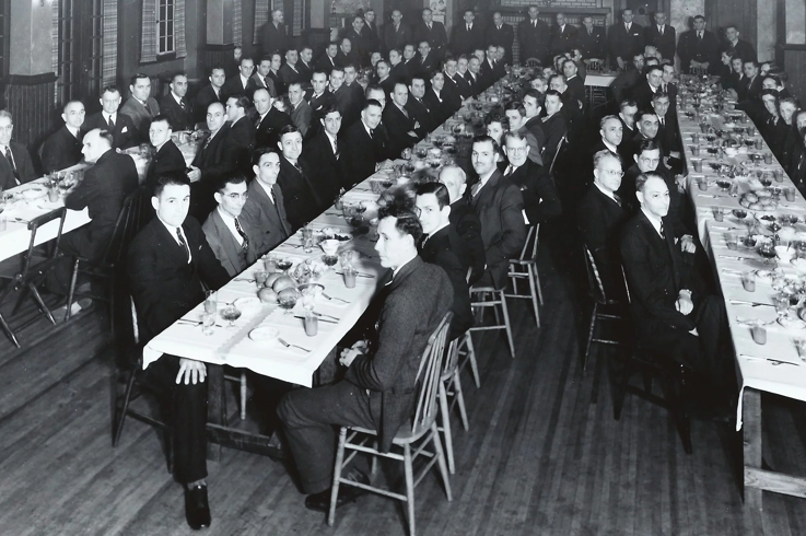 Older image of Union members sitting at table depicting historical Union event