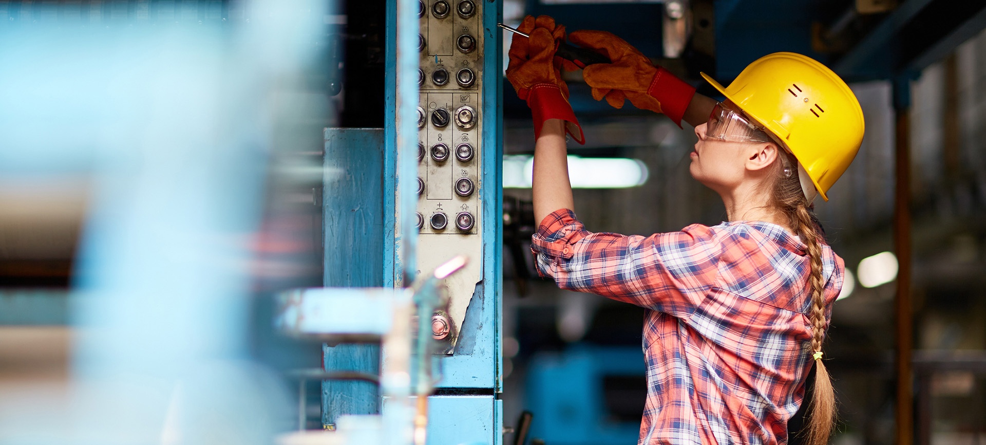 Female construction worker working on panel